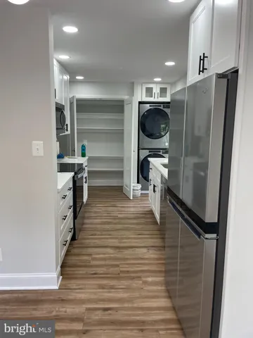 a kitchen with stainless steel appliances a refrigerator and a wooden floor