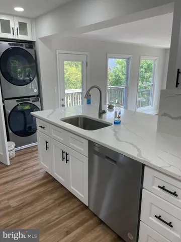 a kitchen with white cabinets and a stove with wooden floor