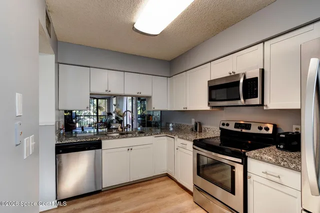 a kitchen with stainless steel appliances granite countertop a sink and a stove