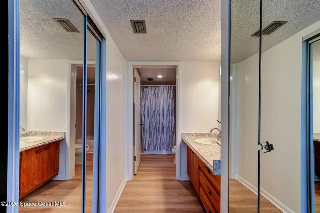 a hallway with closet and wooden floor