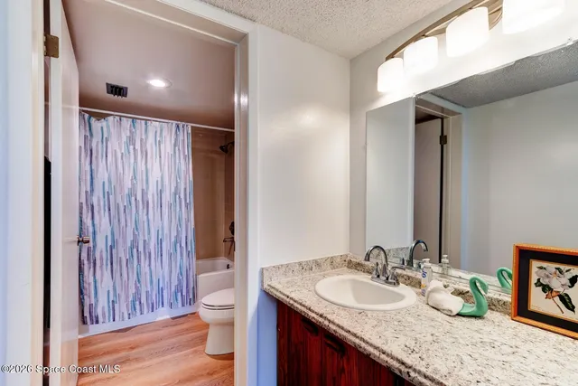a bathroom with a granite countertop sink toilet and shower