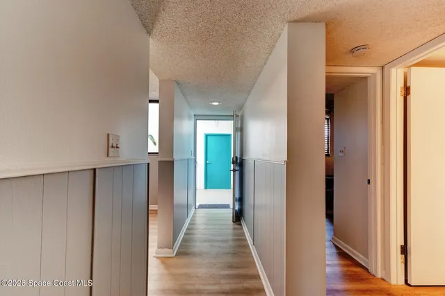 a view of a hallway with wooden floor and closet area