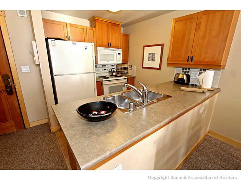 910 Copper Road, Unit 407 Copper Mountain, CO 80443 - Photo 4 of 21 a kitchen with stainless steel appliances granite countertop a sink refrigerator and stove