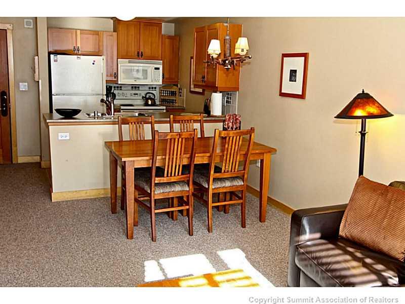910 Copper Road, Unit 407 Copper Mountain, CO 80443 - Photo 7 of 21 a view of kitchen with kitchen island dining table and chairs