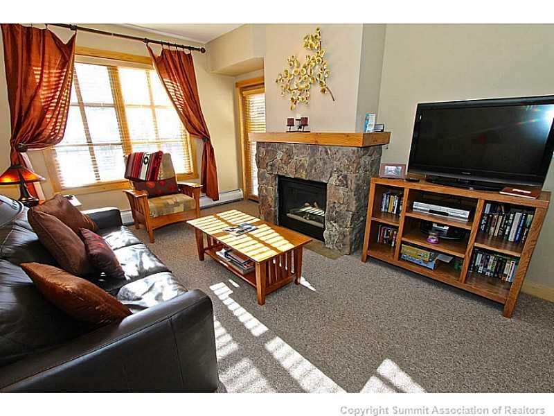 910 Copper Road, Unit 407 Copper Mountain, CO 80443 - Photo 9 of 21 a living room with furniture a flat screen tv and a fireplace