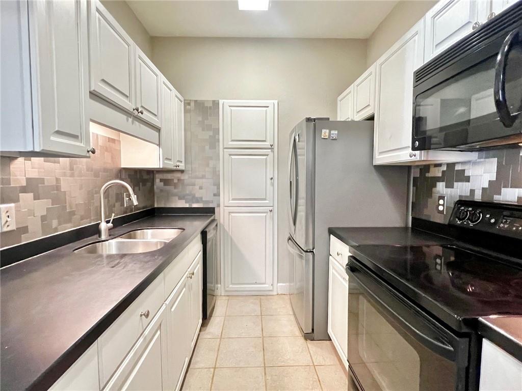 2921 Lenox Road Northeast, Unit 108 Atlanta, GA 30324 - Photo 2 of 9 a kitchen with stainless steel appliances granite countertop a sink stove and refrigerator