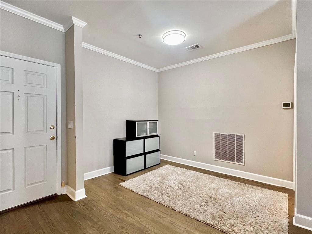 2921 Lenox Road Northeast, Unit 108 Atlanta, GA 30324 - Photo 4 of 9 an empty room with wooden floor and closet