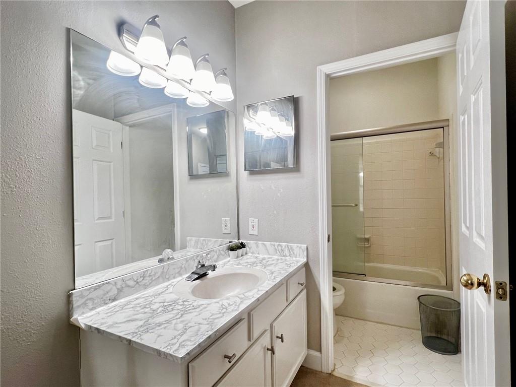 2921 Lenox Road Northeast, Unit 108 Atlanta, GA 30324 - Photo 6 of 9 a bathroom with a granite countertop sink a large mirror and a shower