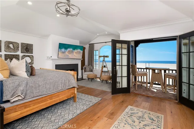 a spacious bedroom with a large bed a chandelier and windows