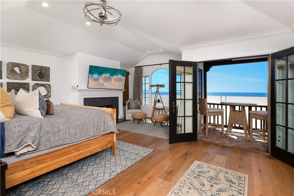 1228 West Oceanfront Newport Beach, CA 92661 - Photo 15 of 32 a spacious bedroom with a large bed a chandelier and windows