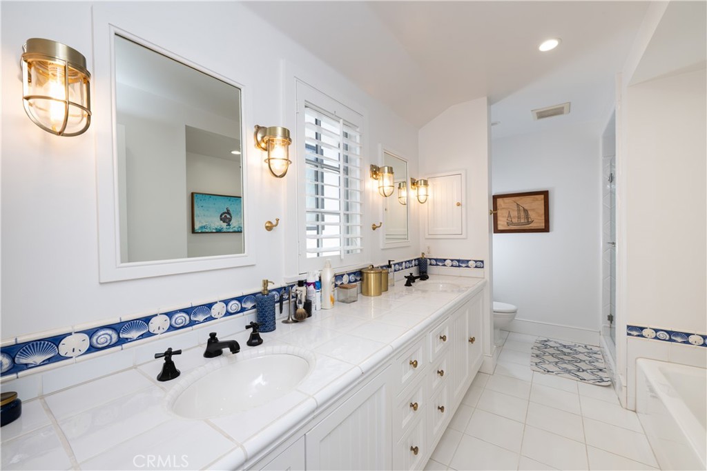 1228 West Oceanfront Newport Beach, CA 92661 - Photo 25 of 32 a bathroom with a double vanity sink mirror and bathtub