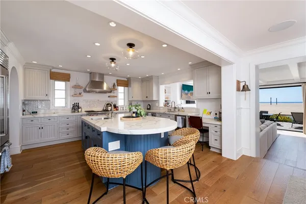 a kitchen with a dining table chairs and wooden floor
