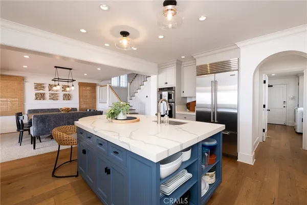a view of kitchen island a sink wooden floor dining table and chairs