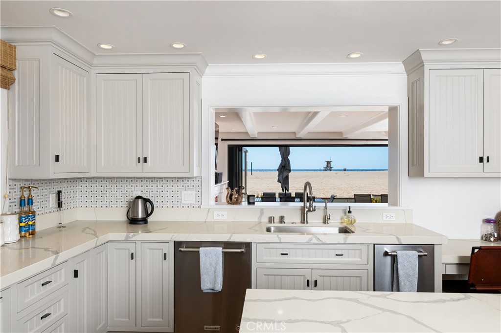 1228 West Oceanfront Newport Beach, CA 92661 - Photo 7 of 32 a kitchen with cabinets appliances a sink and a window