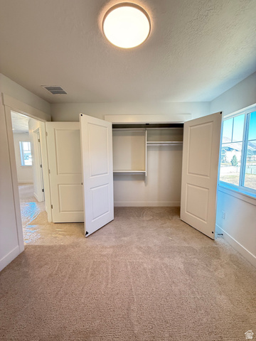 1142 West 220 North Mapleton, UT 84664 - Photo 16 of 26 Unfurnished bedroom with a textured ceiling, a closet, and light carpet
