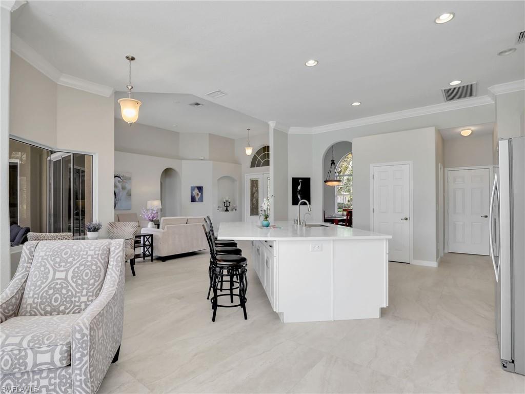 8845 Lely Island Circle Naples, FL 34113 - Photo 44 of 45 a living room with furniture a lamp and kitchen view