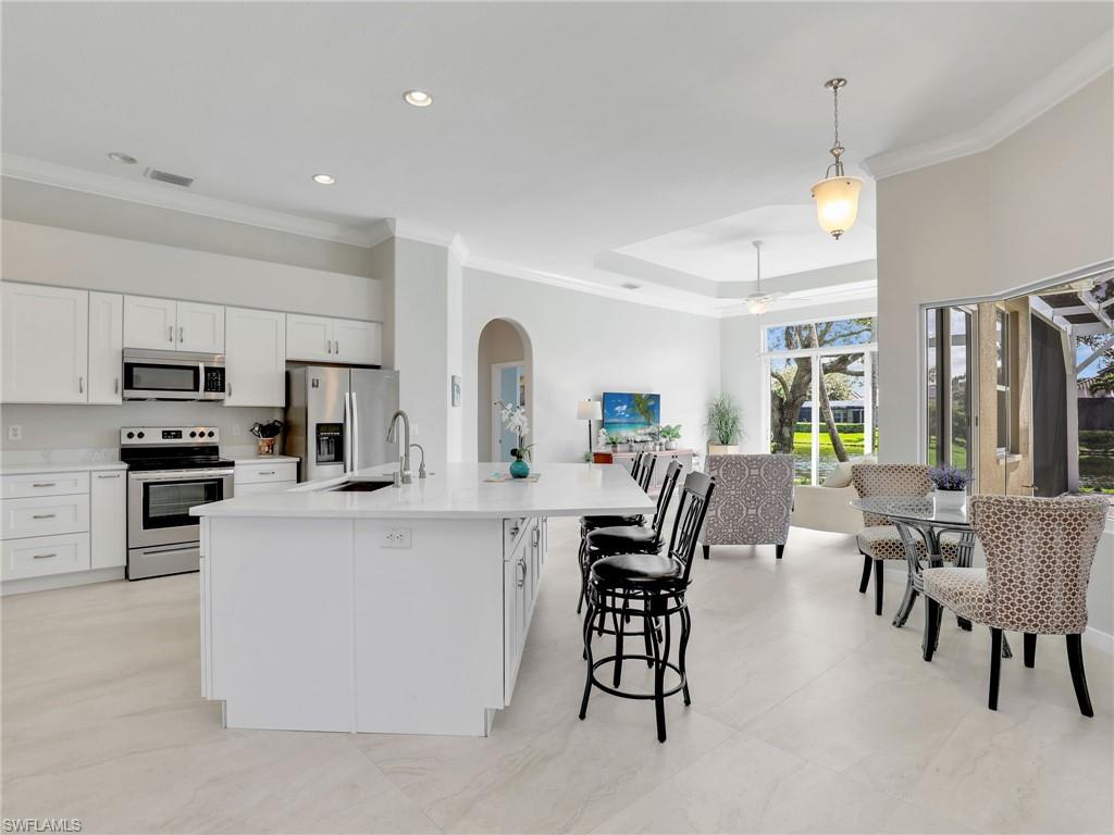 8845 Lely Island Circle Naples, FL 34113 - Photo 45 of 45 a large kitchen with kitchen island a dining table and chairs