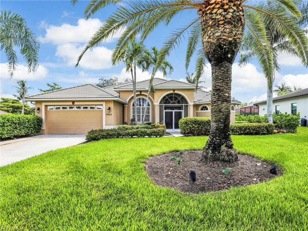 8845 Lely Island Circle Naples, FL 34113 - Photo 2 of 45 a front view of a house with garden