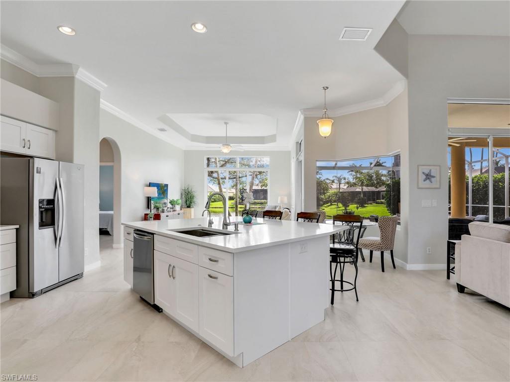 8845 Lely Island Circle Naples, FL 34113 - Photo 19 of 45 a kitchen with stainless steel appliances kitchen island granite countertop a table and chairs in it