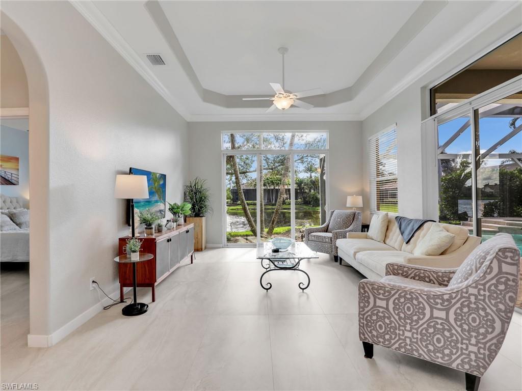 8845 Lely Island Circle Naples, FL 34113 - Photo 24 of 45 a living room with furniture gym equipment and a large window