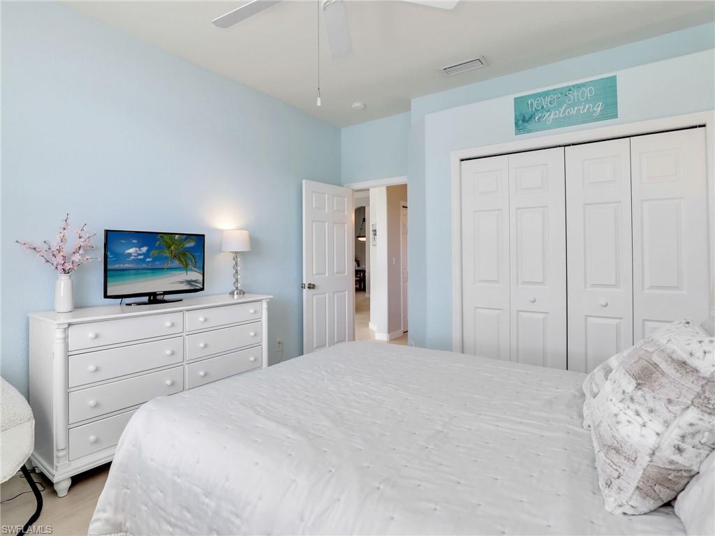 8845 Lely Island Circle Naples, FL 34113 - Photo 25 of 45 a bedroom with a bed and a flat screen tv in it