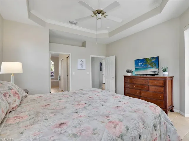 a bedroom with a large bed and a chandelier