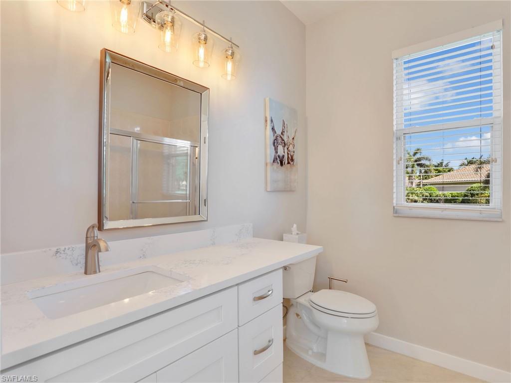 8845 Lely Island Circle Naples, FL 34113 - Photo 34 of 45 a bathroom with a toilet a sink and mirror