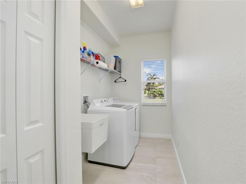 8845 Lely Island Circle Naples, FL 34113 - Photo 35 of 45 a utility room with dryer and washer