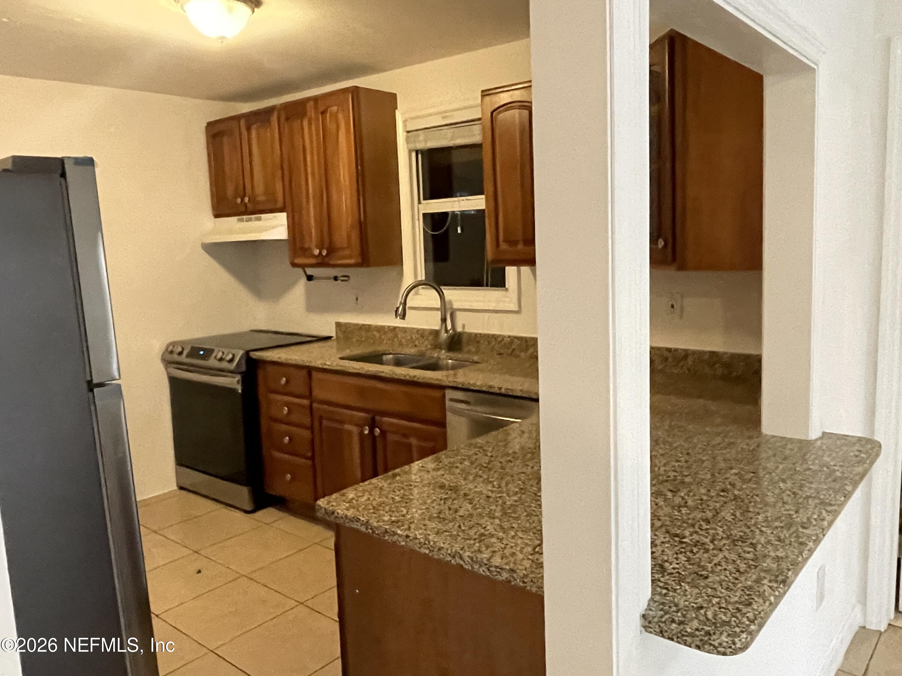 1815 5th Street St. Cloud, FL 34769 - Photo 2 of 9 a kitchen with a stove and a refrigerator