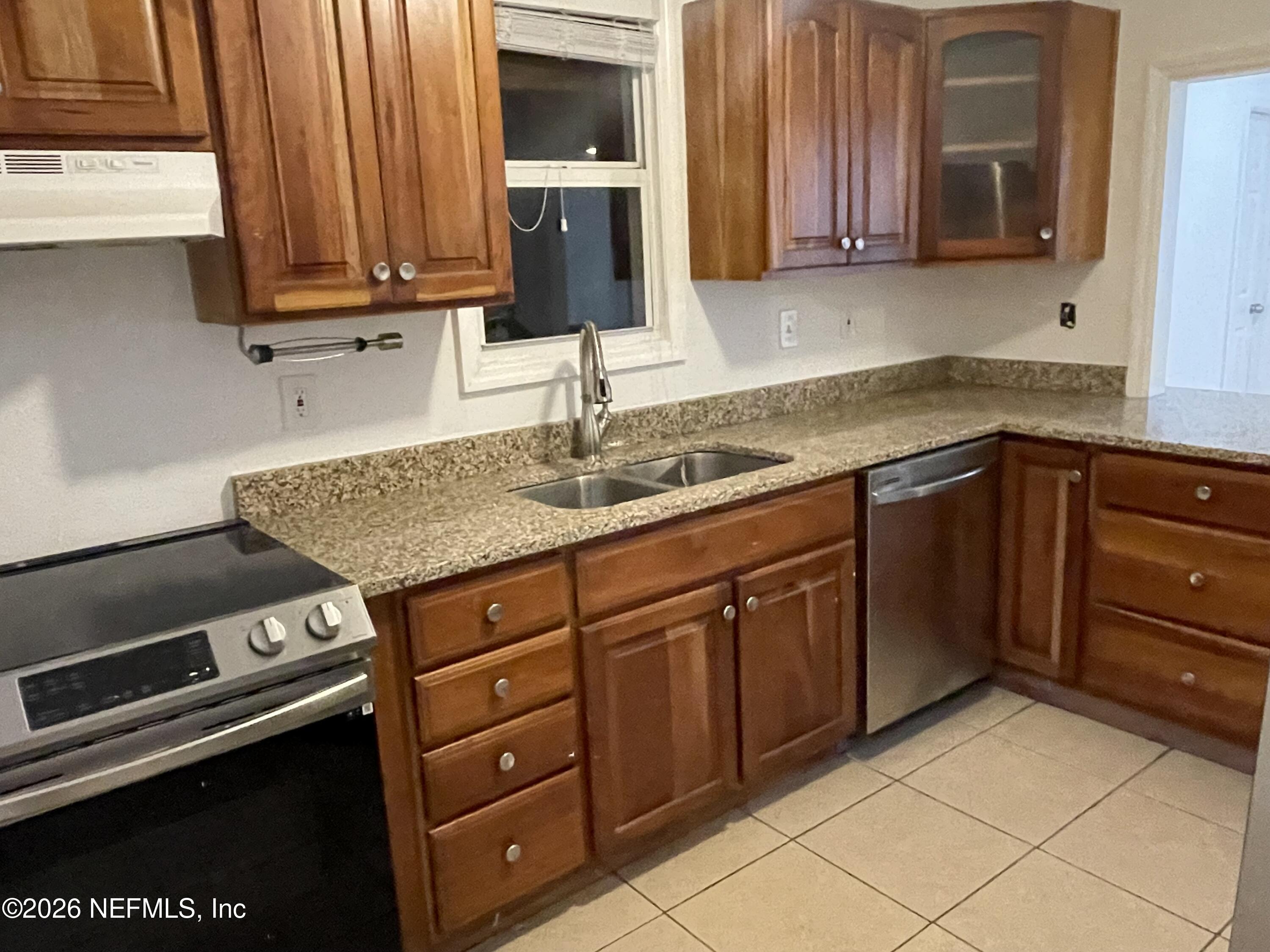 1815 5th Street St. Cloud, FL 34769 - Photo 3 of 9 a kitchen with granite countertop a sink dishwasher stove and cabinets with wooden floor