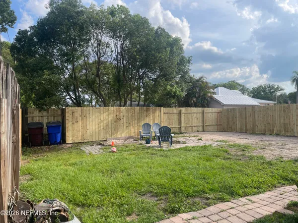 a backyard of a house with table and chairs