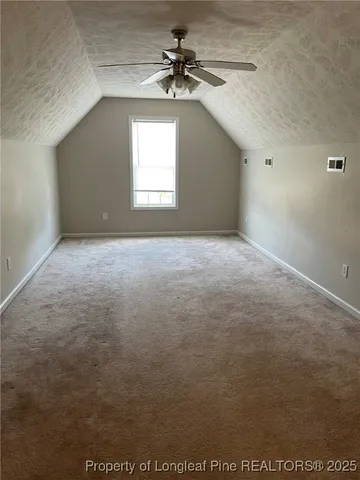 a view of an empty room with a ceiling fan and window