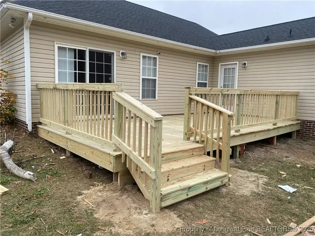 a view of a house with a yard and deck
