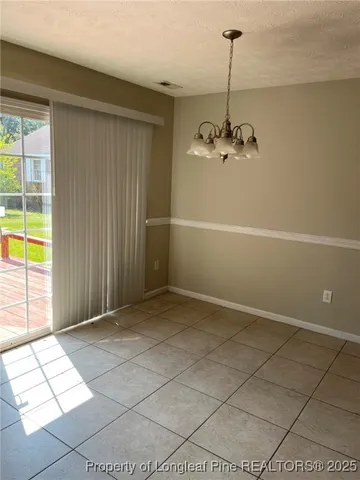 a view of a livingroom with a chandelier fan and windows