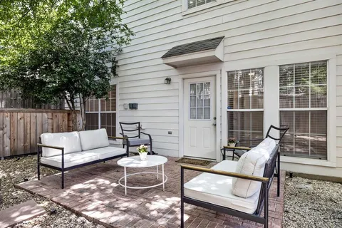 a view of a patio with couches chairs and wooden floor