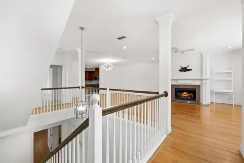 a view of a hallway with wooden floor and staircase