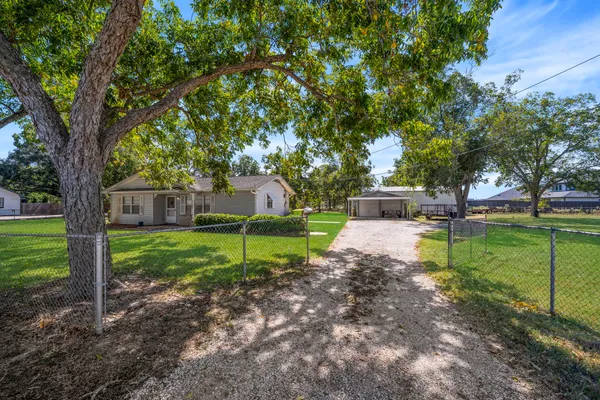 a view of a house with backyard and a tree