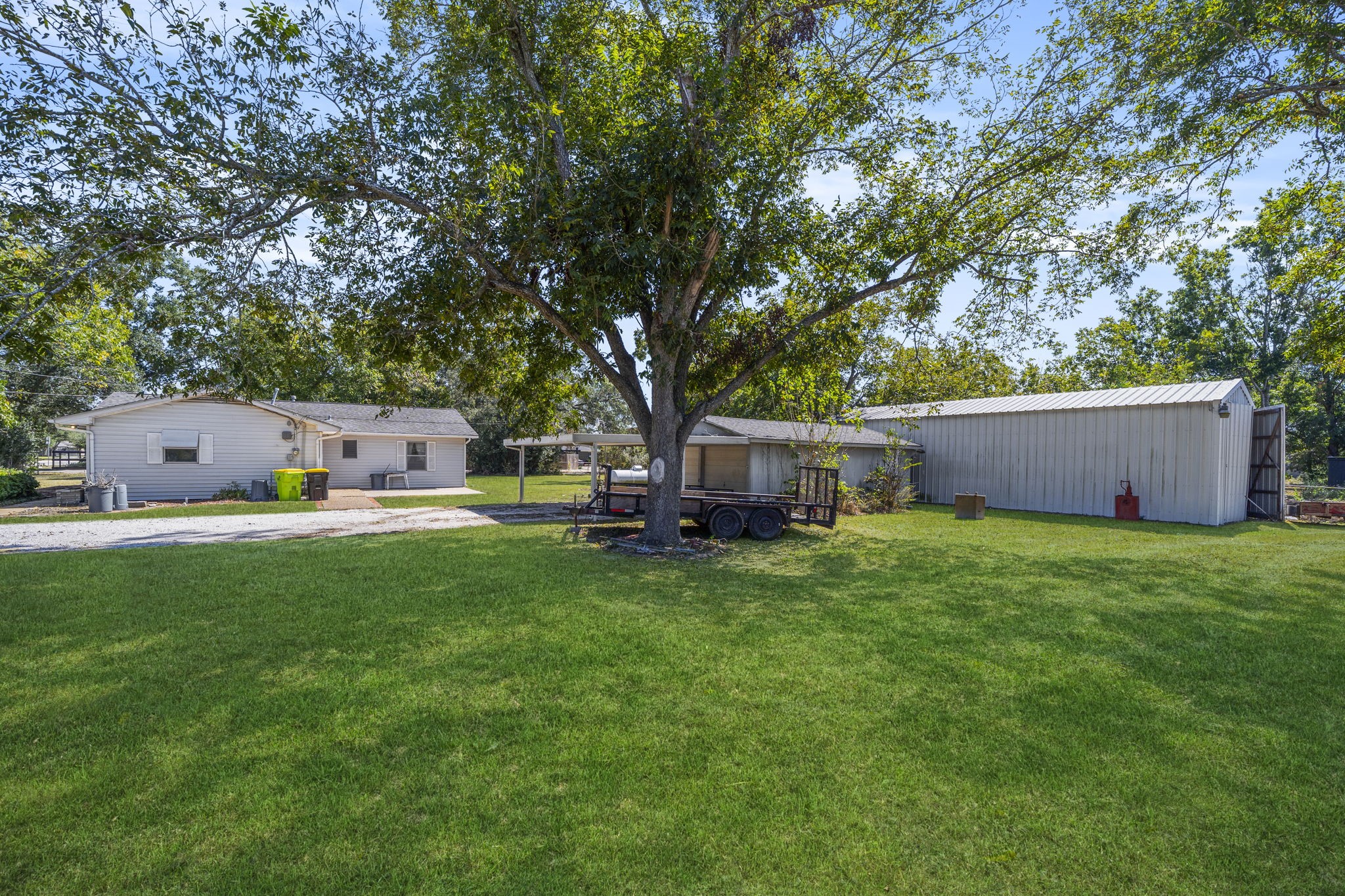 5418 Bryan Road Rosenberg, TX 77469 - Photo 34 of 49 a backyard of a house with table and chairs a barbeque and a large tree