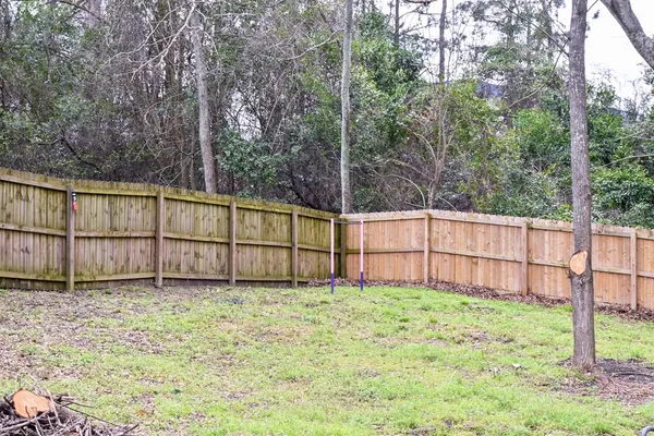 a view of backyard with wooden fence