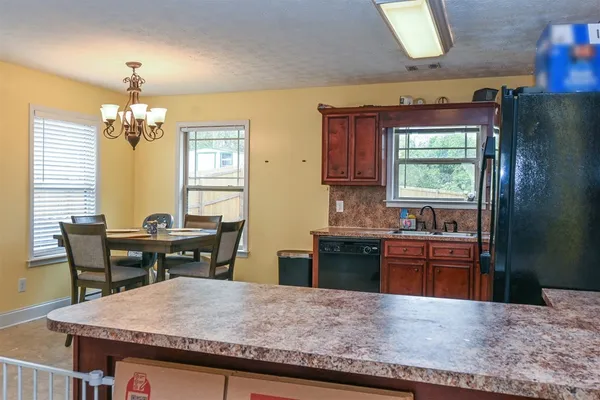 a kitchen with a stove a sink a refrigerator and wooden floor