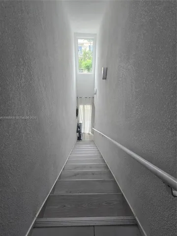 a view of a hallway with wooden floor and entryway