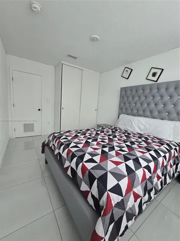 a large bed sitting in a bedroom next to a lamp