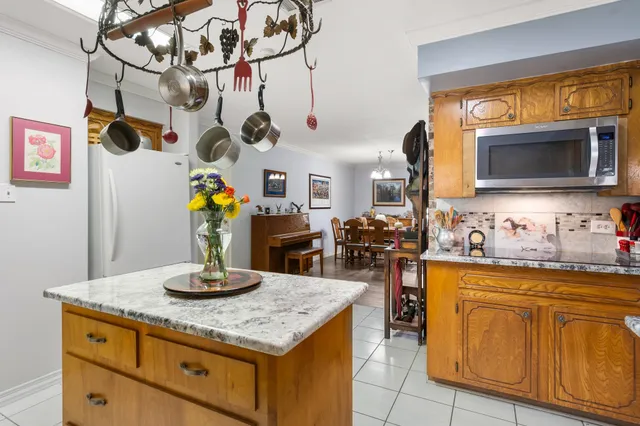 a kitchen with a sink a microwave and living room view