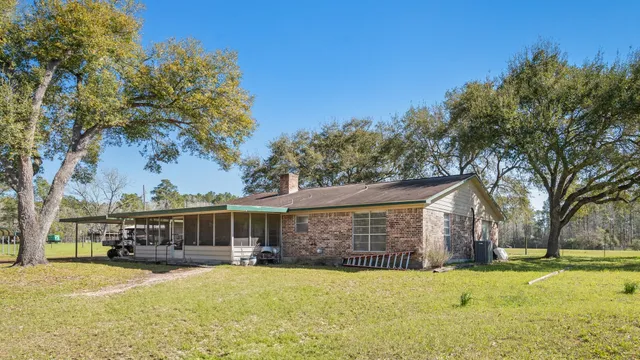 a front view of house with yard and trees in the background