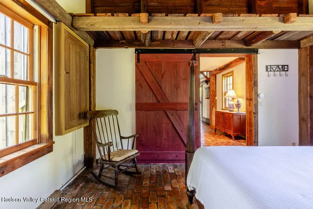 a bedroom with a bed and a large window