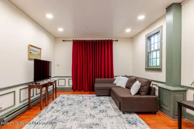 a living room with a bed and wooden floor