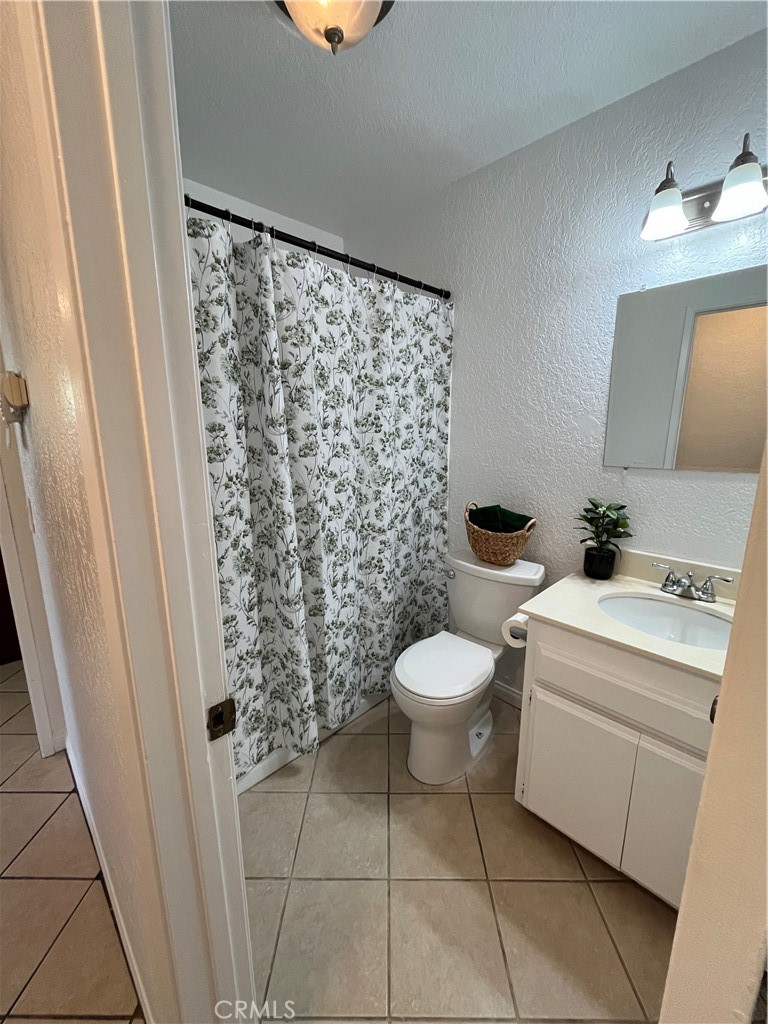 3842 Ridge Road Riverside, CA 92501 - Photo 14 of 26 a bathroom with a toilet and a shower curtain