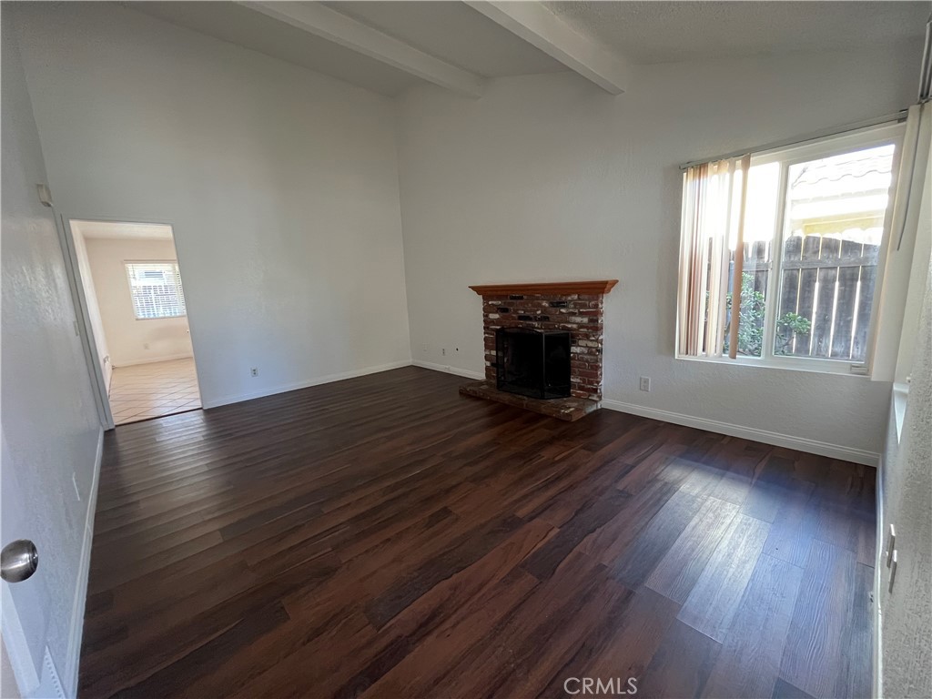3842 Ridge Road Riverside, CA 92501 - Photo 4 of 26 an empty room with wooden floor fireplace and windows