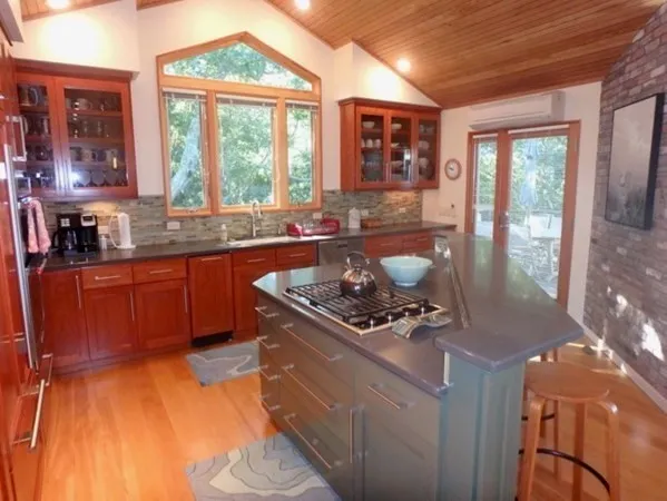 a kitchen with a stove a sink and a wooden cabinets