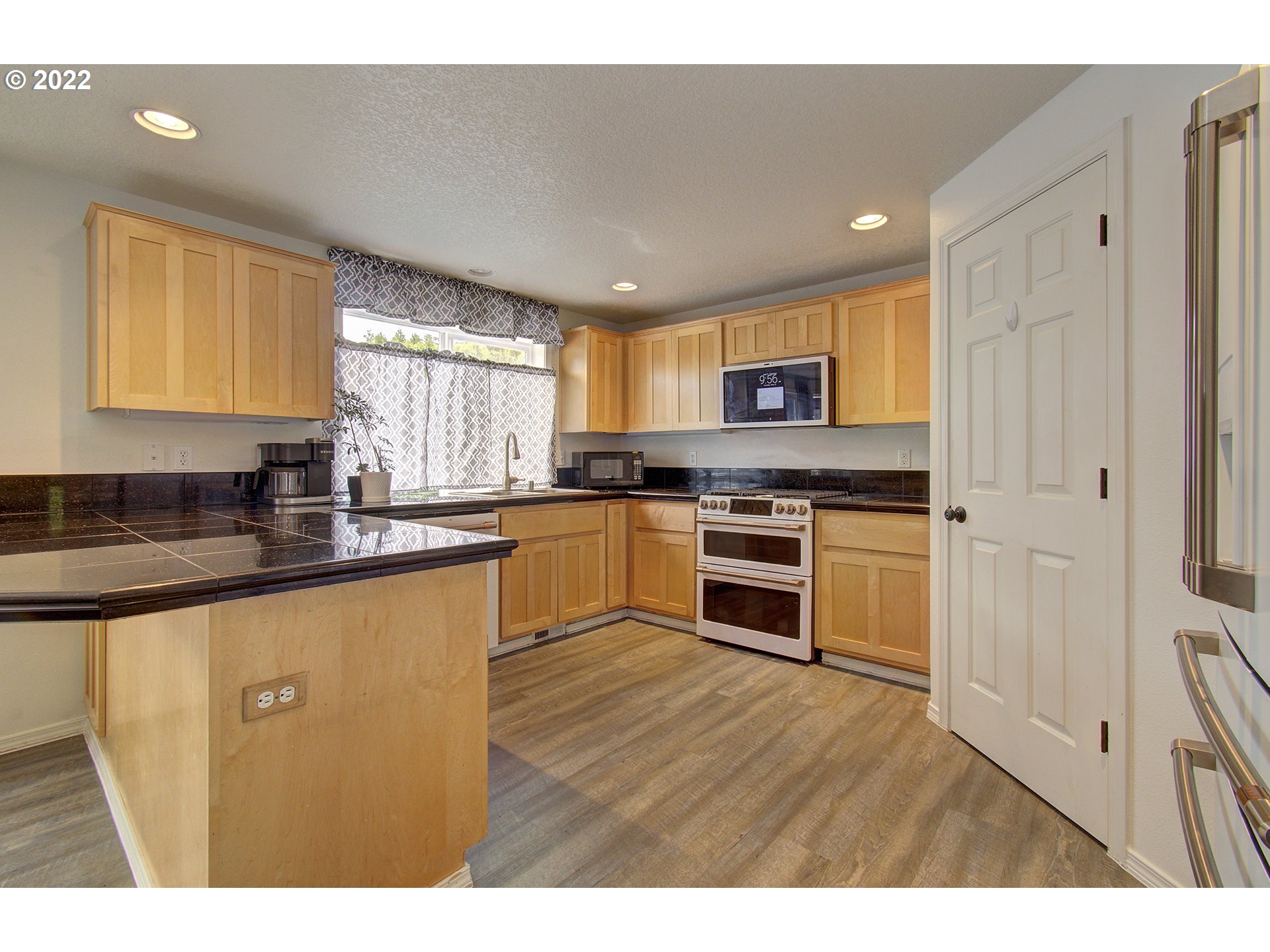 810 Raven Drive Ridgefield, WA 98642 - Photo 8 of 32 a kitchen with stainless steel appliances granite countertop a stove a sink and a microwave